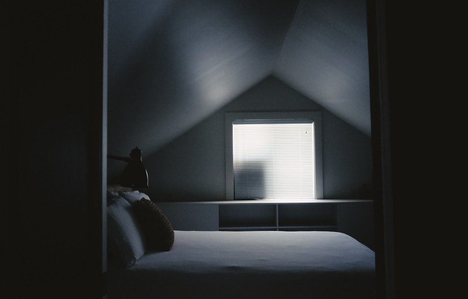 Image of a loft room with a bed and window